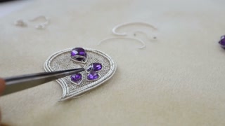 Master fits topaz on nacklace by tweezers