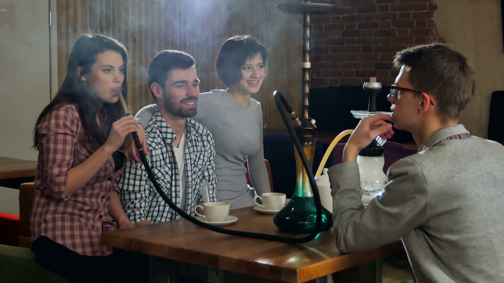 Young Friends Smoking Hookah In Shisha Cafe Stock Footage SBV315456678