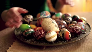 Woman arranging easter egg plate, focus on hand