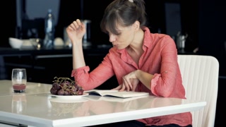 Elegant woman enjoying a book in the kitchen