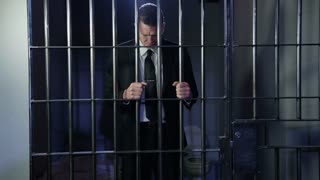 White collar crime - holding bars looking remorseful business man financial crime HD