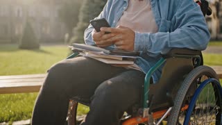 Disabled man sits in wheelchair checking social networks