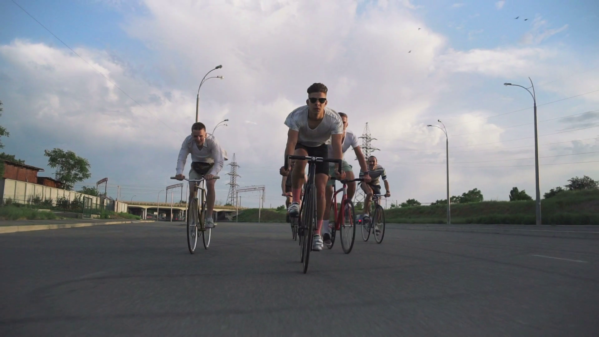 Group of cyclists riding fixed gear bikes on the road, shot