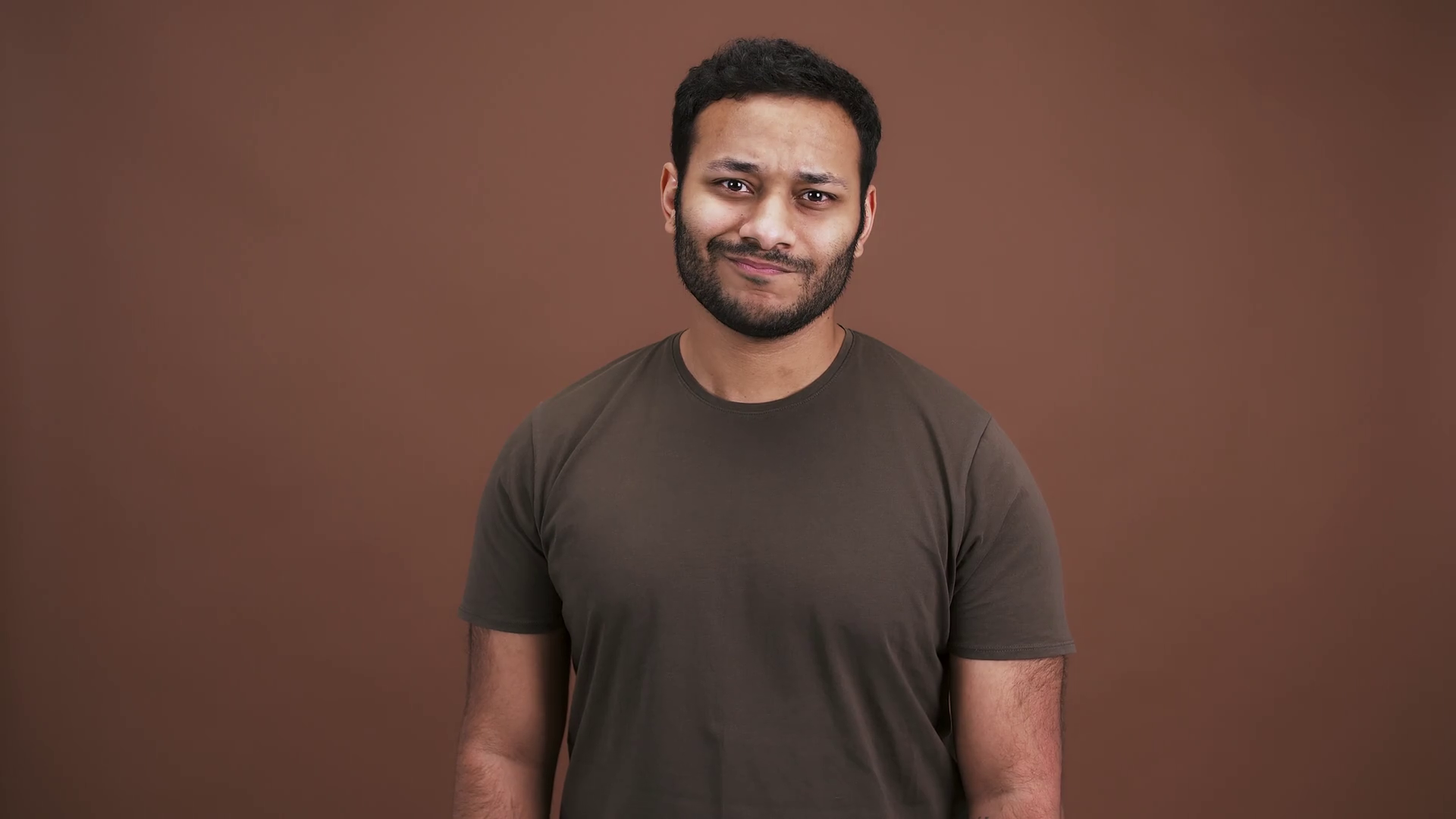 Unhappy indian guy gesturing thumbs up with both hands, expressing