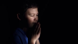 Light shines on the praying boy