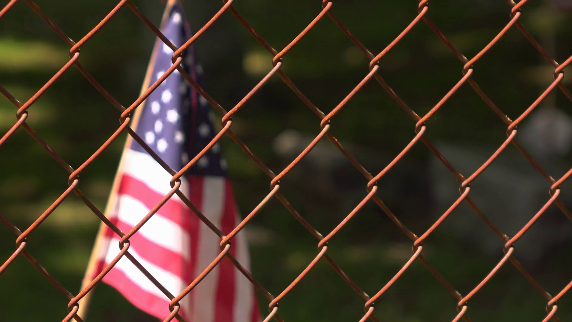 American flag behind chain link fence waving 4k Stock Video Footage