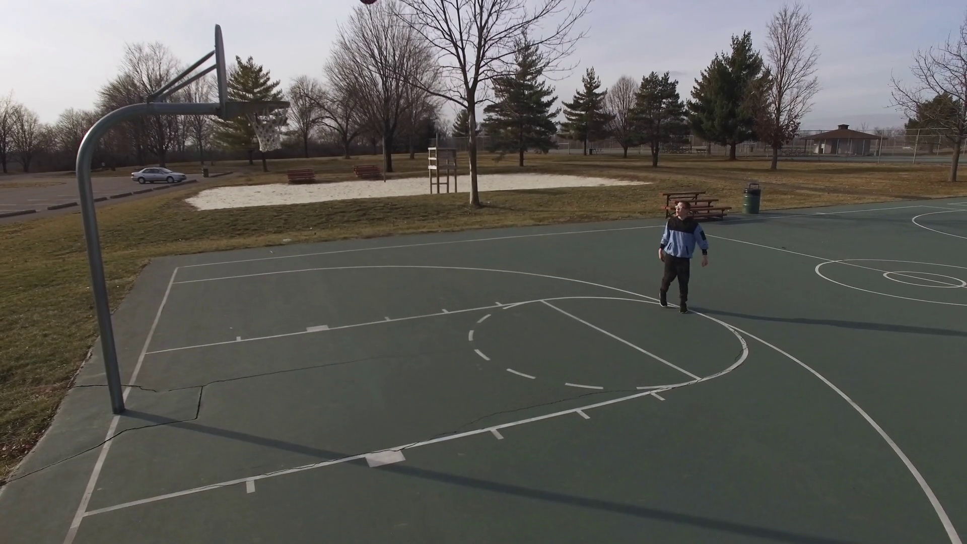 Boy on basketball court shooting practice shots aerial view 4k Stock