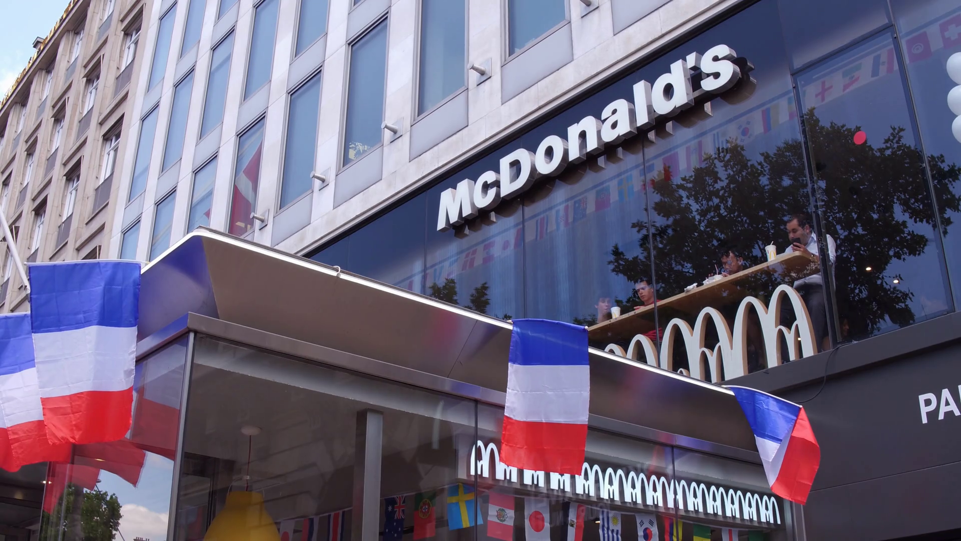 McDonalds building exterior with French Flags in Paris 4k