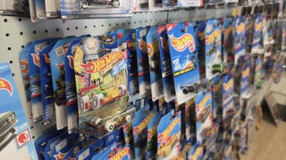 Person buying a Hot Wheels car at store 4k