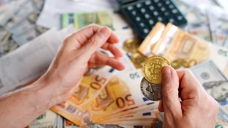 Hands shows BTC bitcoin against the dollars and euros