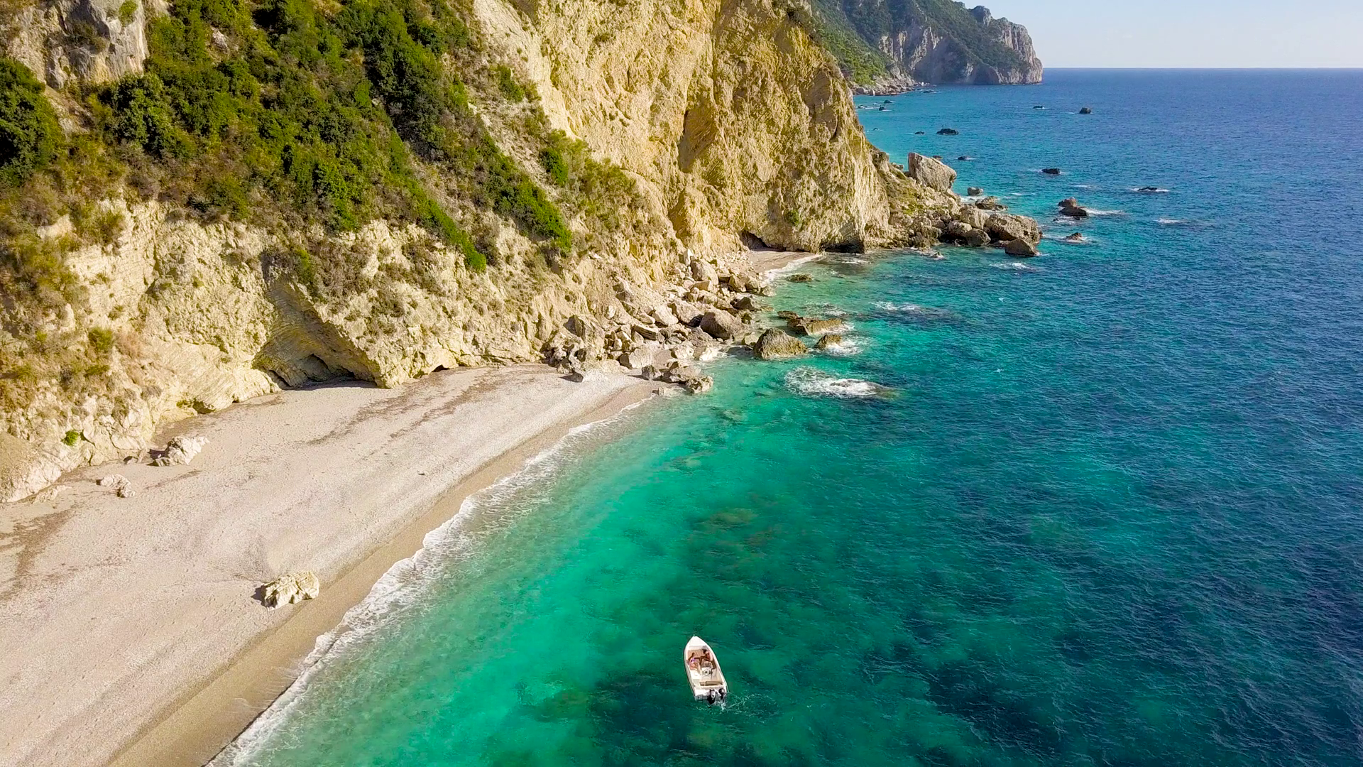 Aerial view of a boat in front of the Corfu island in Greece. Amazing beach with a turquoise and