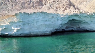 Ship sails along Musandam peninsula, Sultanate of Oman, Gulf of Oman. Oman - arab country in southeastern coast of the Arabian Peninsula. Musandam - governorate of Oman, located on Musandam peninsula