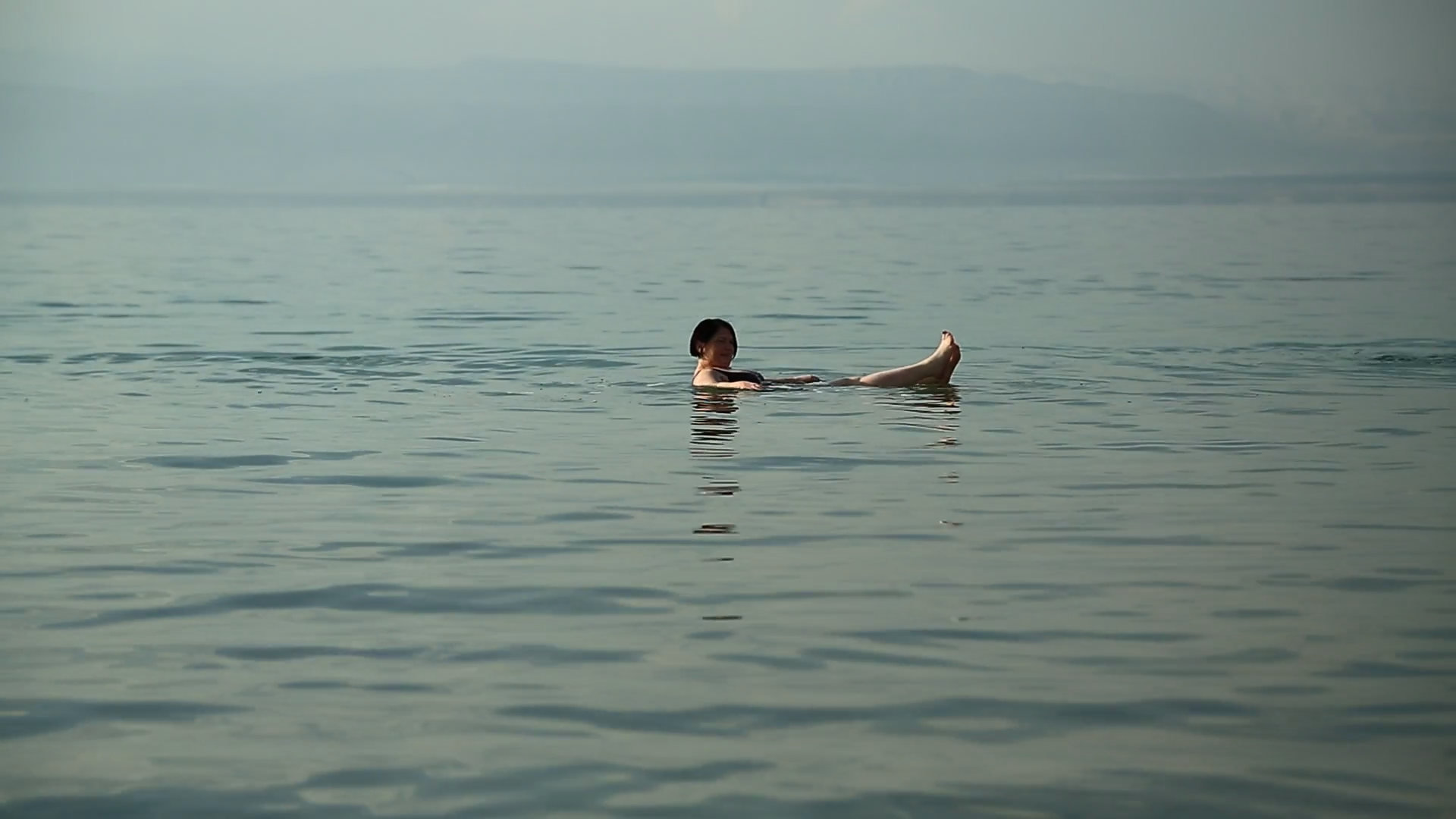JORDAN, DEAD SEA, DECEMBER 8, 2016 Woman swim and relax in very salty