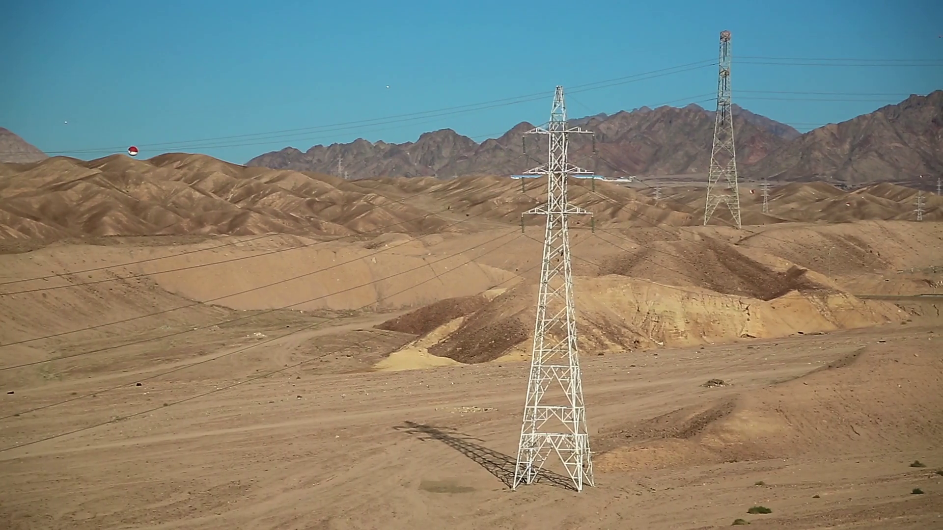 Power transmission towers in desert in Jordan. Overhead power line