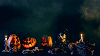 Jack-o-lantern Sits at a table with pumpkins lanterns. Then he says goodbye and disappears