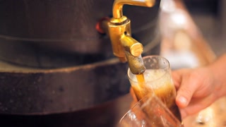 A bartender is pouring a dark beer