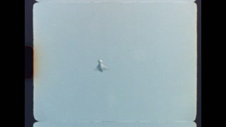 Authentic archival footage capturing the iconic Concorde supersonic passenger jet flying at high altitude, with a distinct retro film look