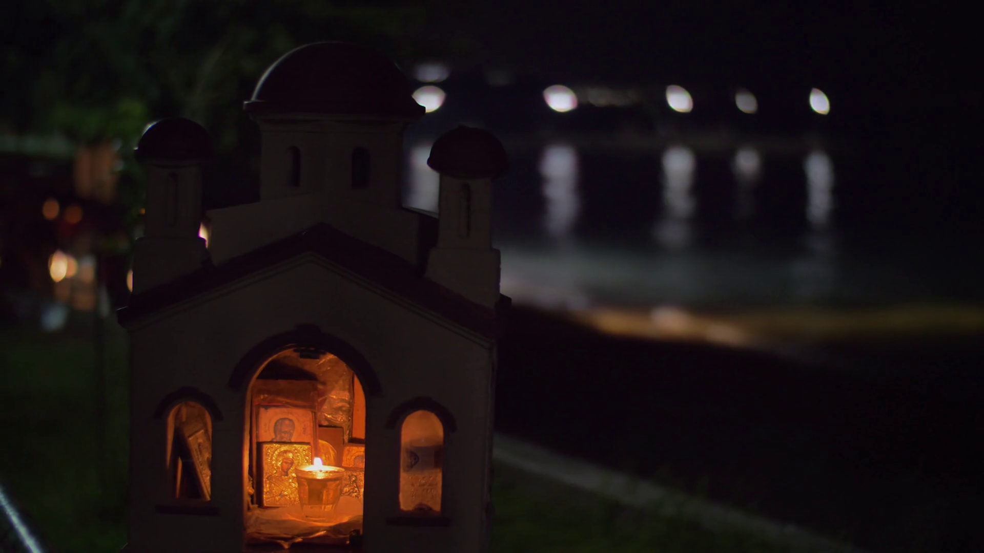 Slow motion shot of the candle light and images of saints inside the