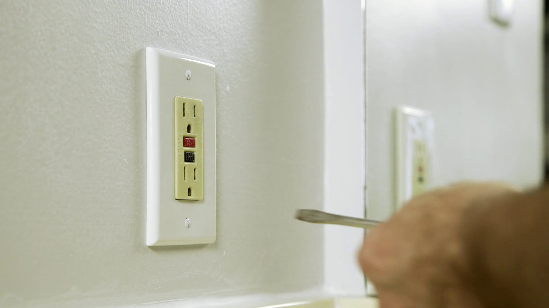 electrician removing the outlet cover to a ground fault outlet 4k Stock