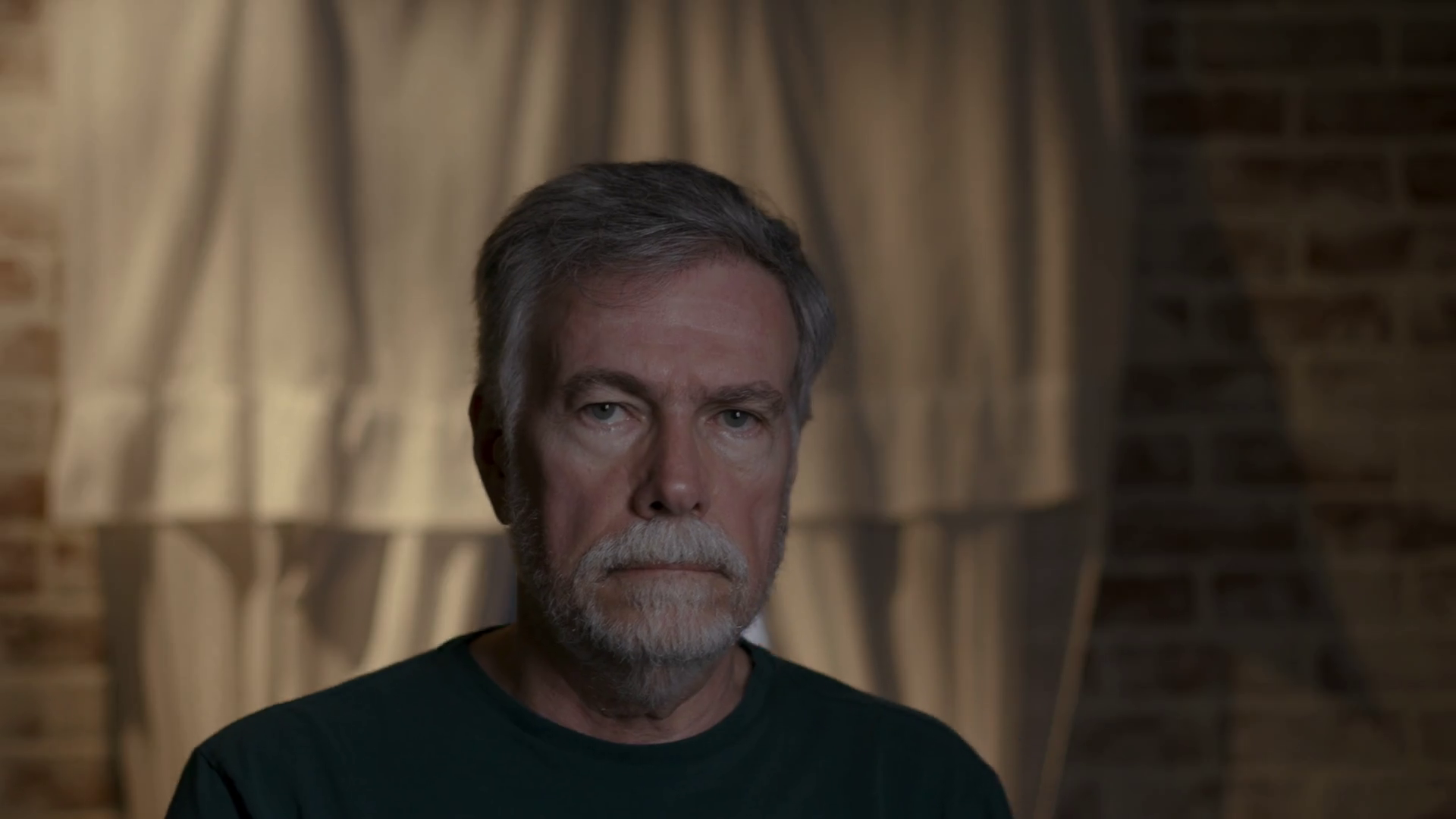 senior man walks toward camera and stares with a solemn look Stock