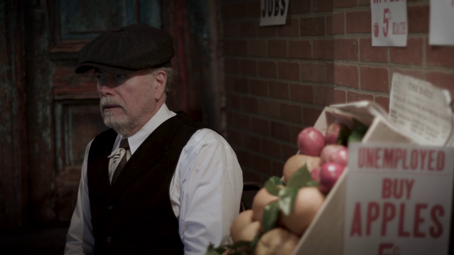 unemployed man during the great depression holding an apple to sell