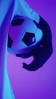 Close-up dynamic shots of a football player holding a classic black and white soccer ball and wearing cleats and long socks in vibrant