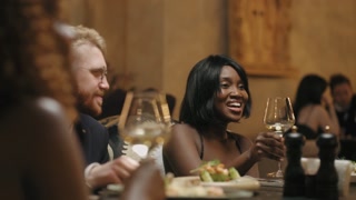 happy multiracial people celebrate Birthday of Christmas in restaurant, black woman giving toast