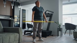 Active Overweight Woman Doing Exercise At Home, Holding Fitness Stick, Squatting, Healthy Lifestyle