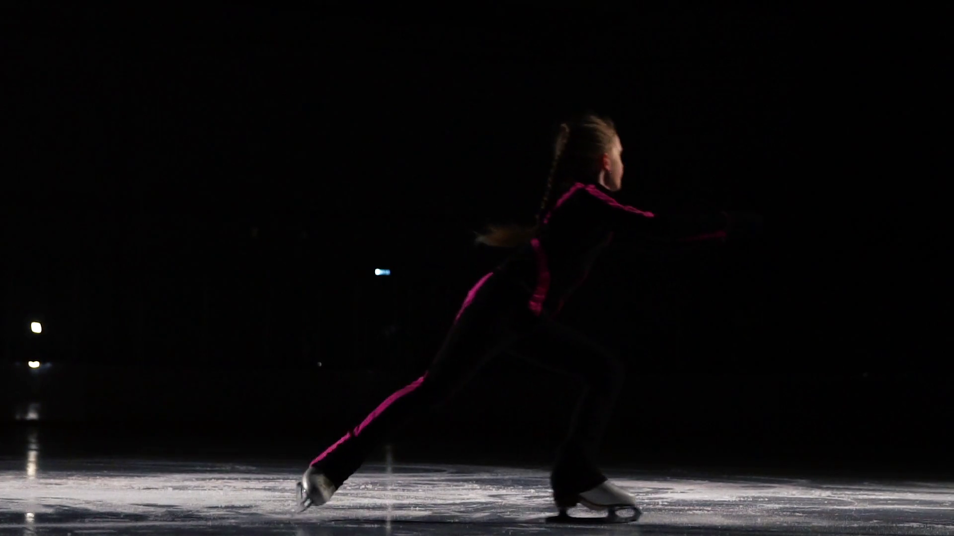 A professional skater performs a skating jump with the rotation in the