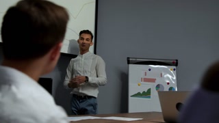 A young employee reports on progress and development plans for the busy quarter on a projector diagram