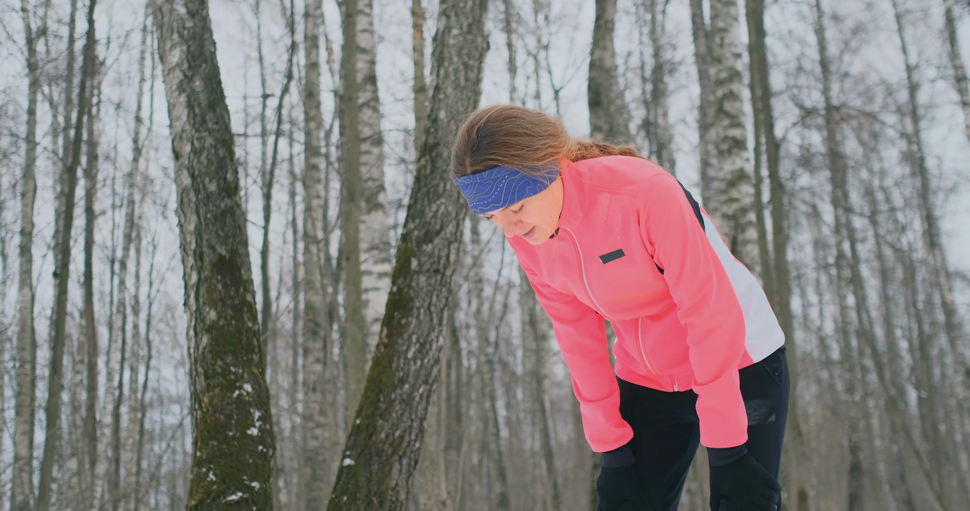 A young woman on a morning jog in the winter forest was tired and