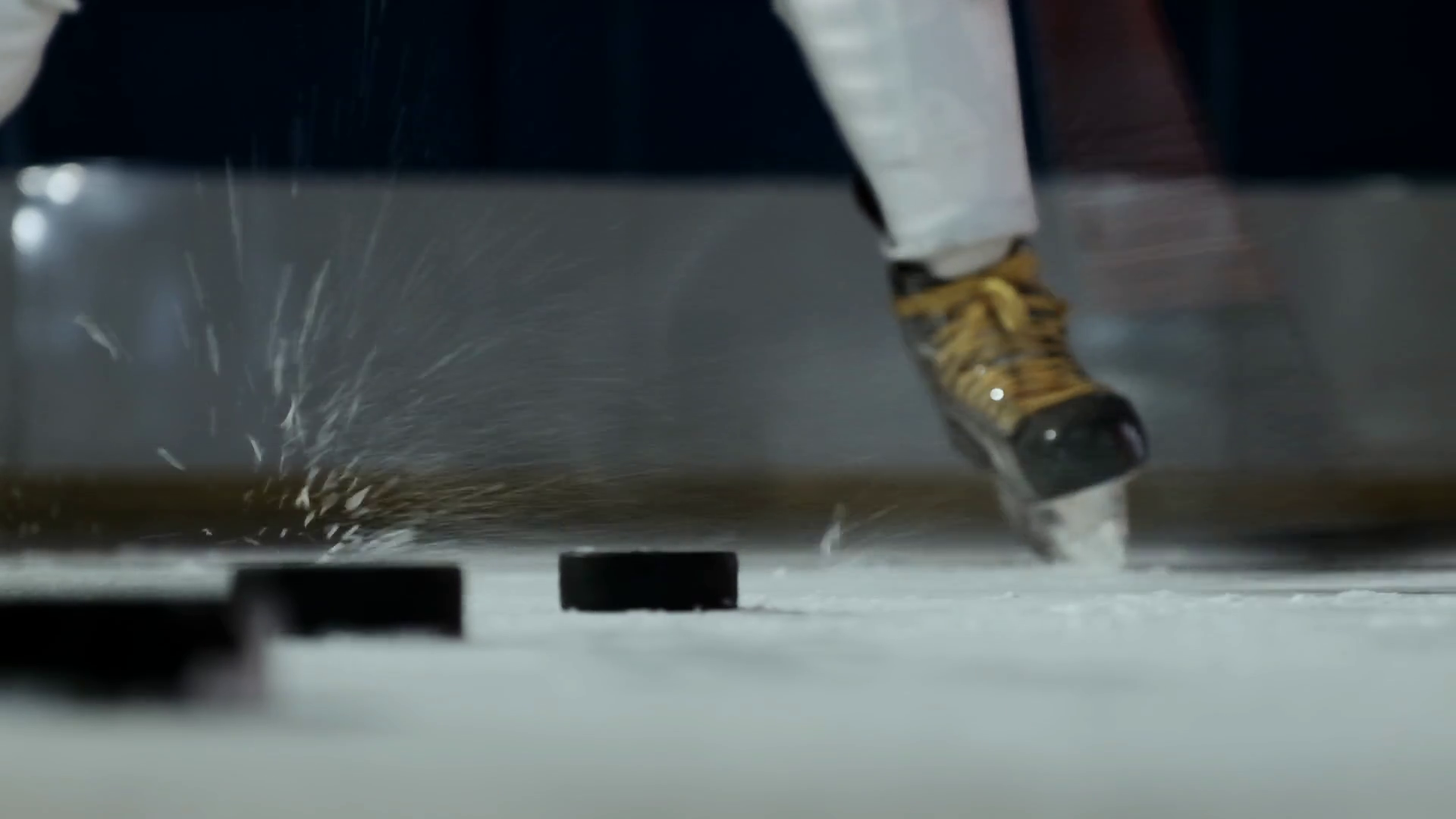 Close-up of the puck on the ice and the hockey player strikes the puck ...