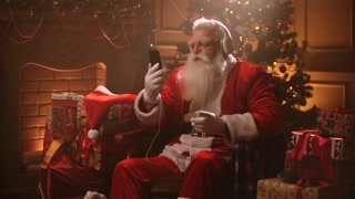 happy Xmas holidays of Santa Claus, old wizard is sitting in house and listening to song by headphones
