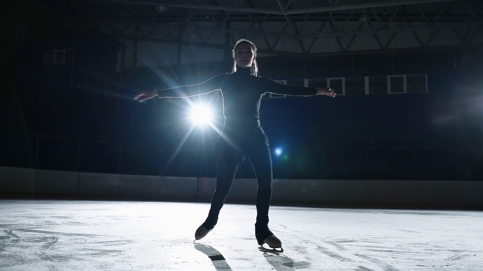 talented and inspired young sportswoman is skating alone on ice rink at