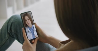 Woman using medical app on smartphone consulting with doctor via video conference. Female using online chat to talk with family therapist and checks possible symptoms during pandemic of coronavirus.