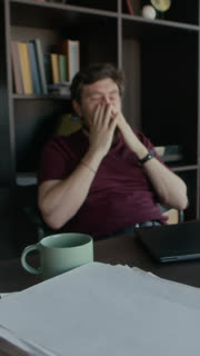 Vertical dolly in shot of tired mature Caucasian male author hitting wall while working on novel, crumpling paper draft and throwing it away