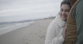 Handheld shot of asian mixed race couple kissing and smiling on the beach