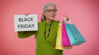 Elderly granny woman showing Black Friday inscription banner text, advertising discounts, low prices