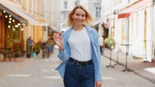Woman tourist smiling friendly at camera waving hands gesturing invitation hello hi greeting goodbye