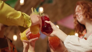 Friends toasting cocktails, having a summer party cafe
