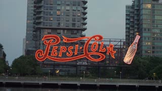 NEW YORK, USA - JULY 12, 2025: A stunning view of the classic PepsiCola neon sign, brightly lit at dusk by the picturesque waterfront