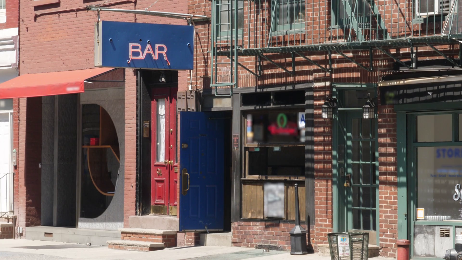 A daytime summer establishing shot of a typical Manhattan bar entrance