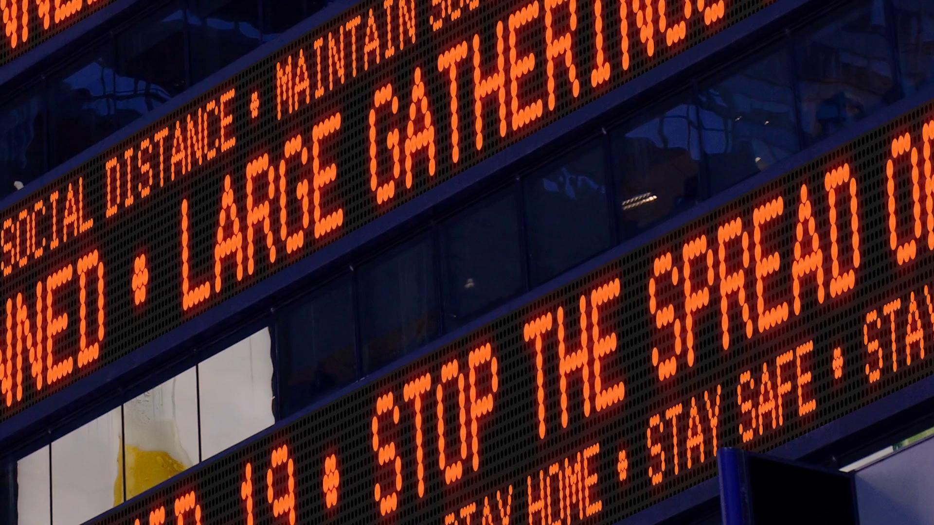 Closeup view of a Times Square ticker tells pedestrians to stay safe