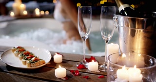 Champagne glass, food and hot tub couple arrive, enter and romantic partner bonding on Valentines day date