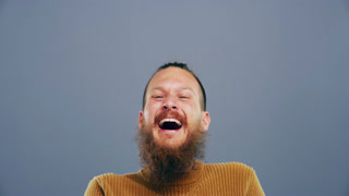 Funny, man and laughing in studio with face of happiness, freedom or reaction to joke