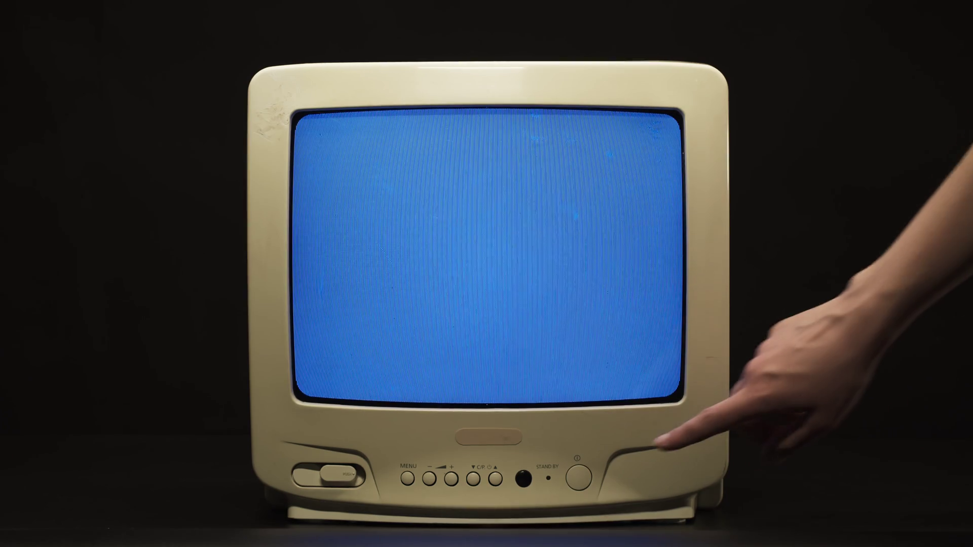 Turning off old retro square television with blue screen on black