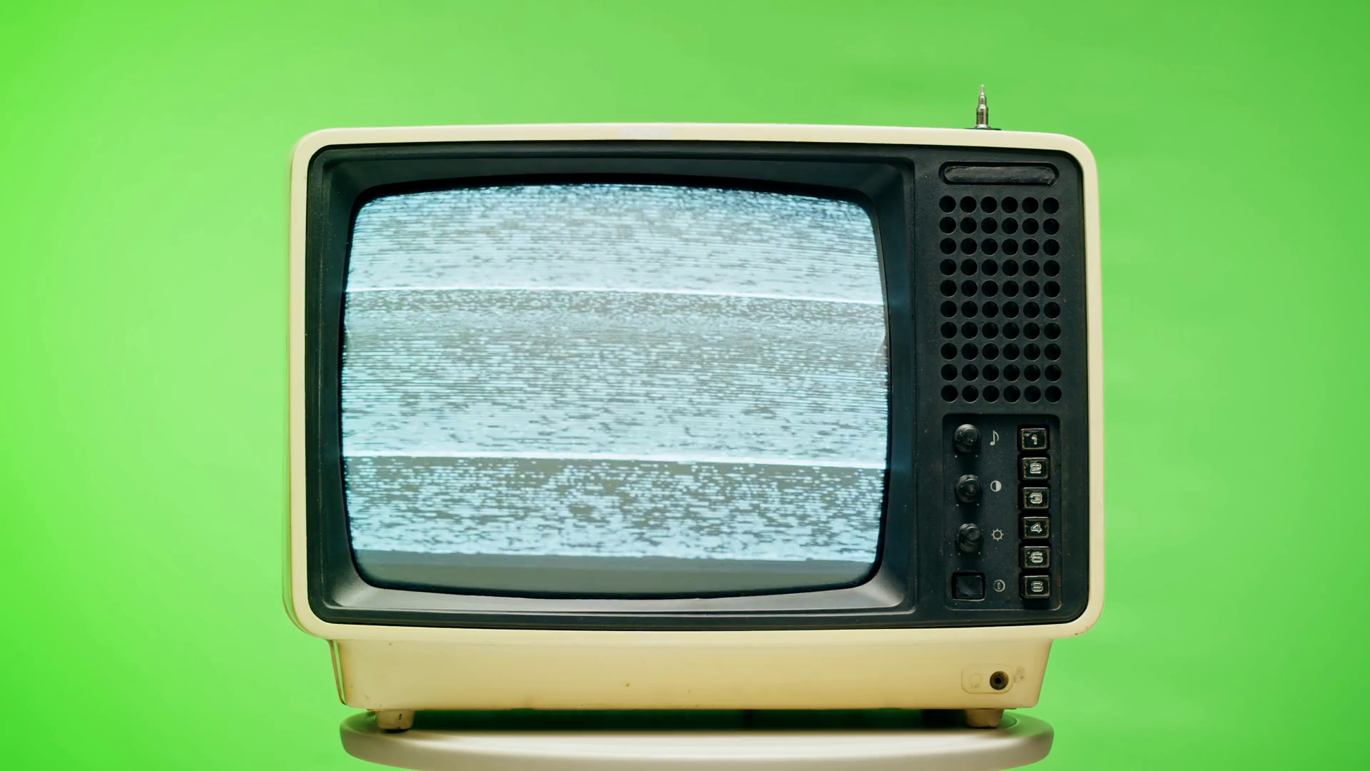 Old television with grey interference screen on chroma green background. Closeup of vintage tv