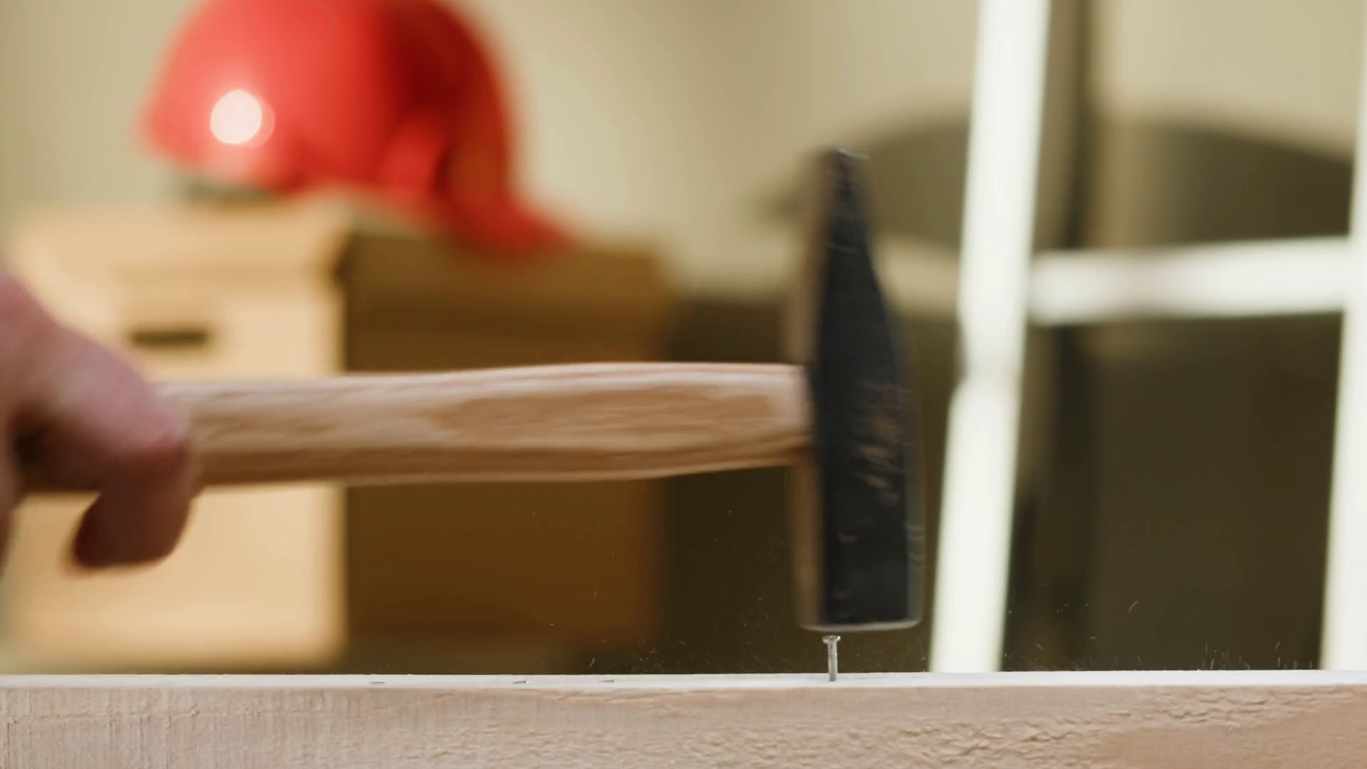 Hammering nails into wood closeup, man builder using hammer