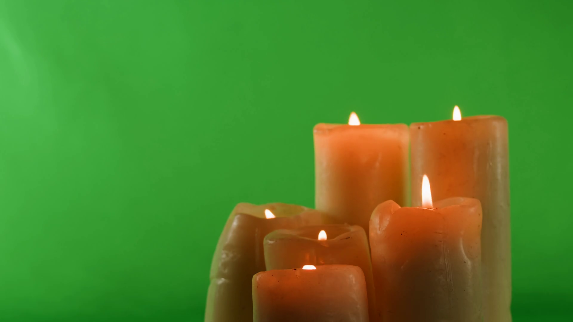 Burning wax candles on green chroma key background. Fire flame candlelight closeup. Stock Video