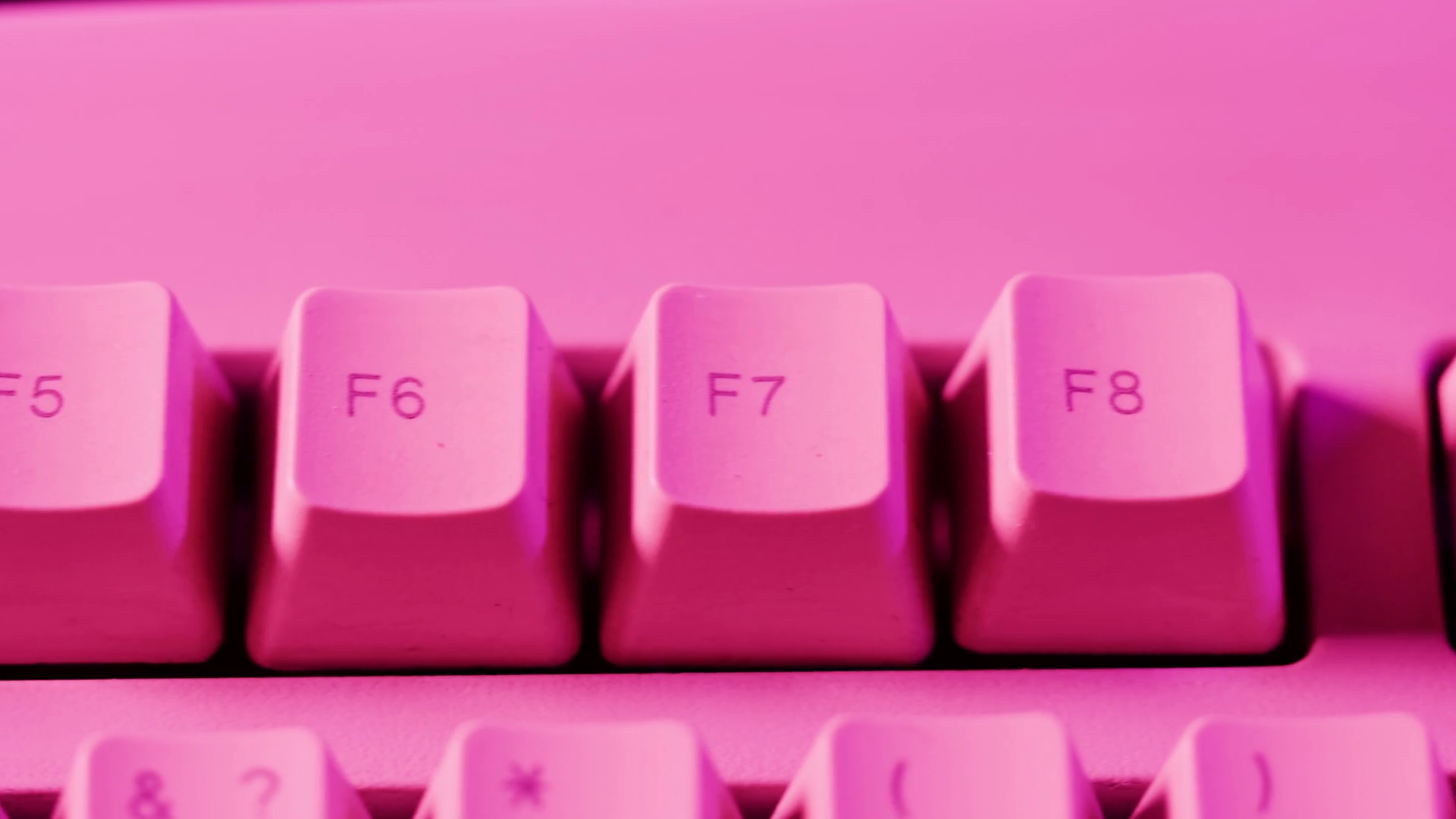Old retro keyboard closeup. Computer buttons in neon pink light top